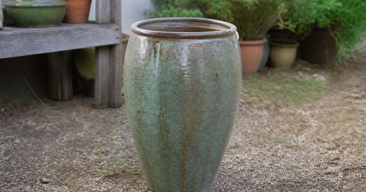 Large ceramic planter standing upright on garden ground surface