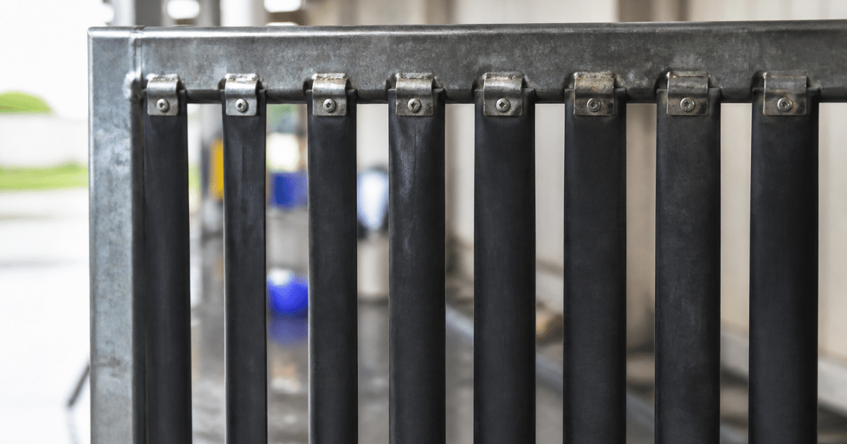 Bandes caoutchouc noires fixees verticalement sur cadre metalique porte