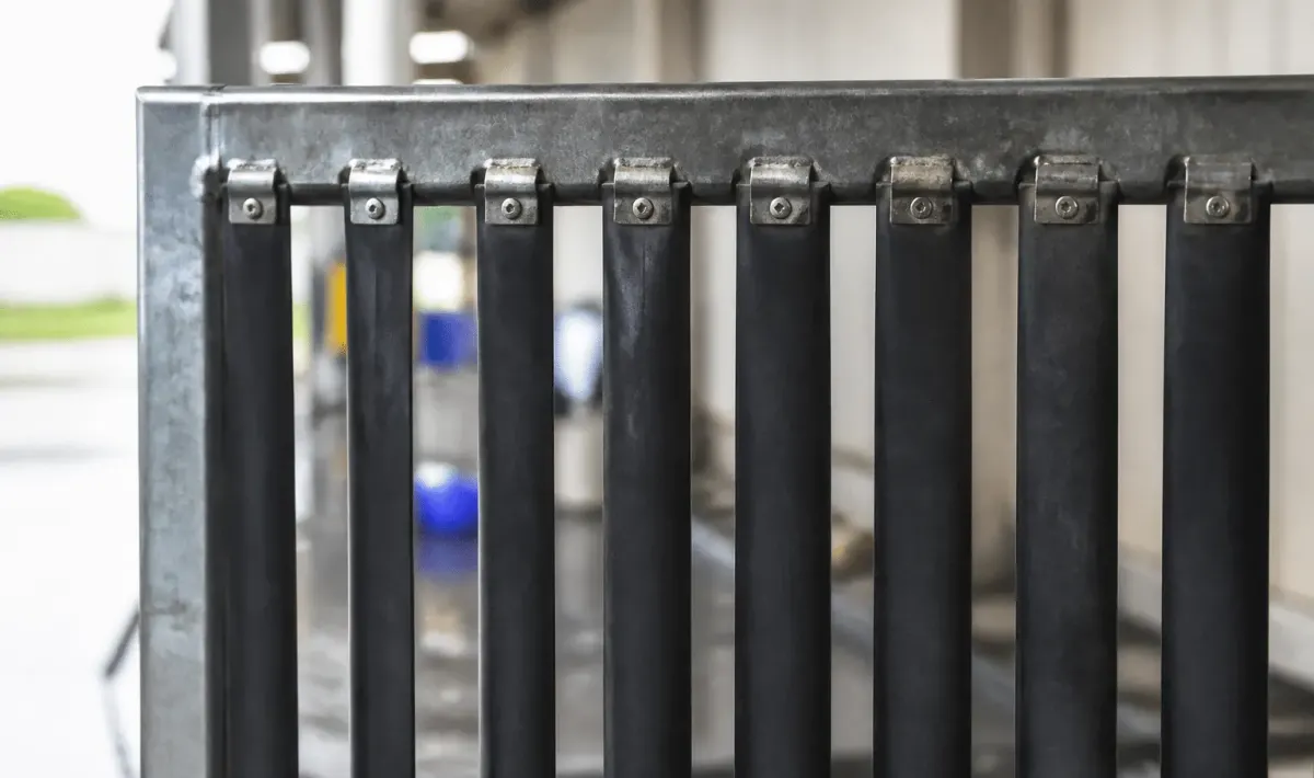 Bandes caoutchouc noires fixees verticalement sur cadre metalique porte