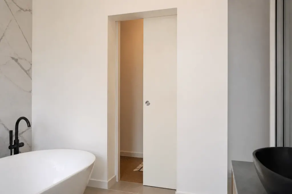 Porte coulissante encastree dans mur blanc salle bain