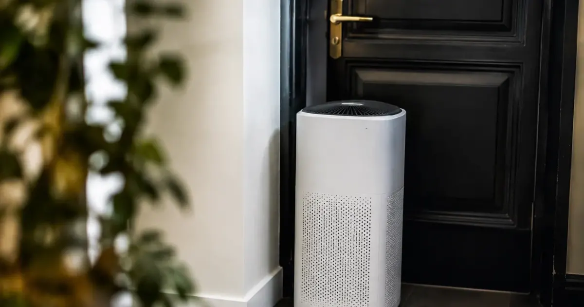 Appareil blanc debout contre une porte de palier sombre