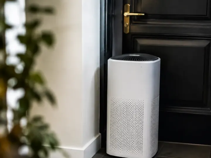 Appareil blanc debout contre une porte de palier sombre
