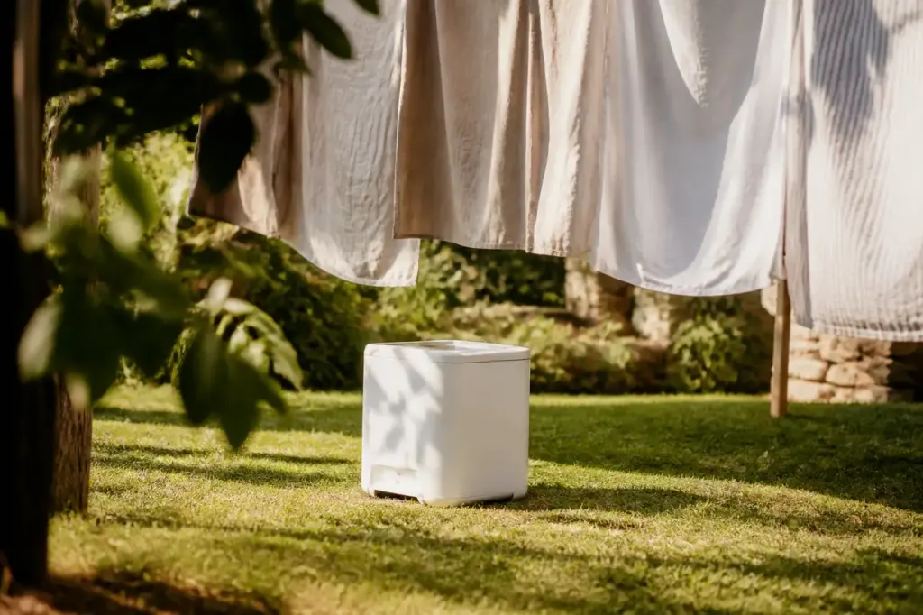 Appareil blanc pose au sol sous linge suspendu