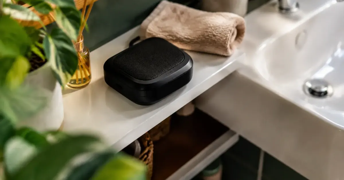 Appareil noir posé sur étagère blanche près du lavabo