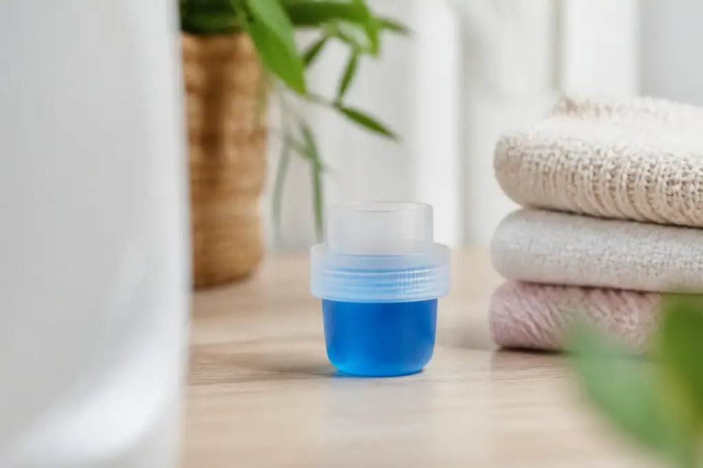 Bouchon doseur gradue rempli de lessive liquide bleue