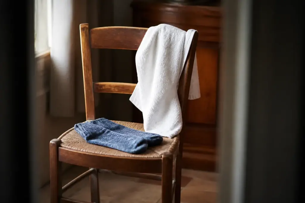 Chaussettes bleues et serviette blanche sur chaise en bois
