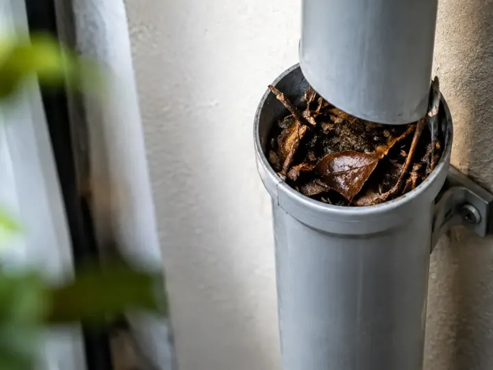 Debris bruns bouchant un tuyau vertical fixe au mur