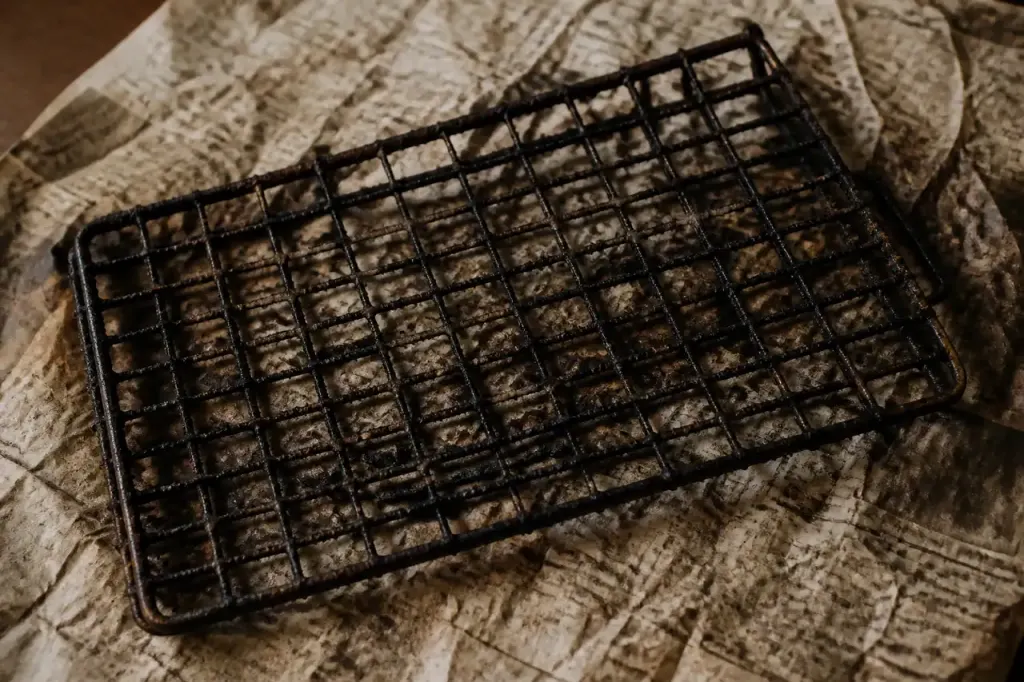 Grille metallique encrassee posee sur du papier journal