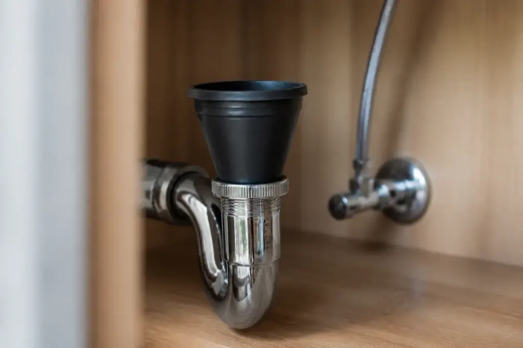 Joint conique noir pose sur un siphon chrome