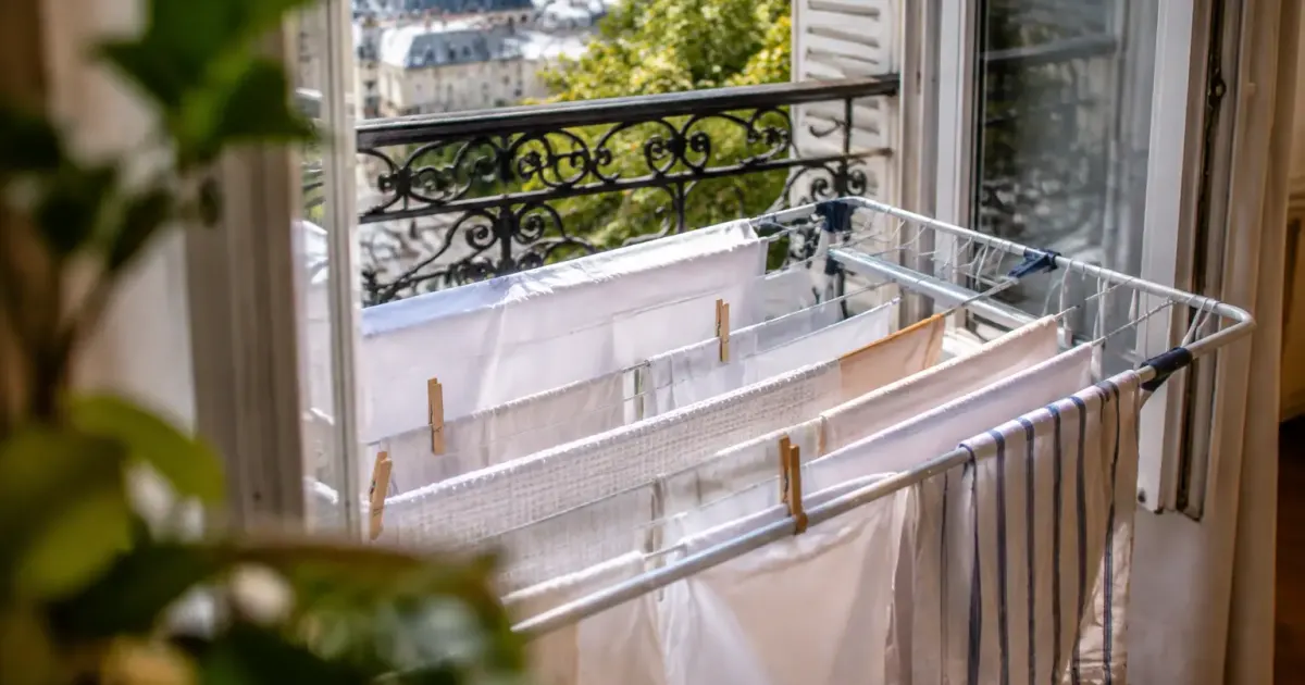 Linge blanc suspendu sur un etendoir pres fenetre ouverte