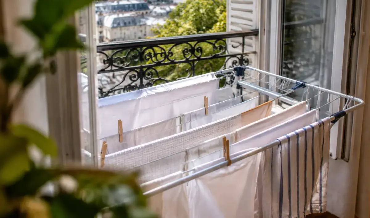 Linge blanc suspendu sur un etendoir pres fenetre ouverte