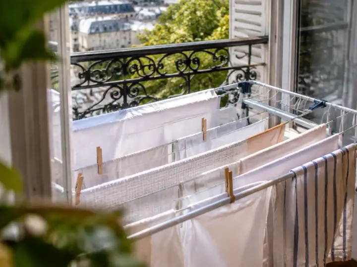 Linge blanc suspendu sur un etendoir pres fenetre ouverte