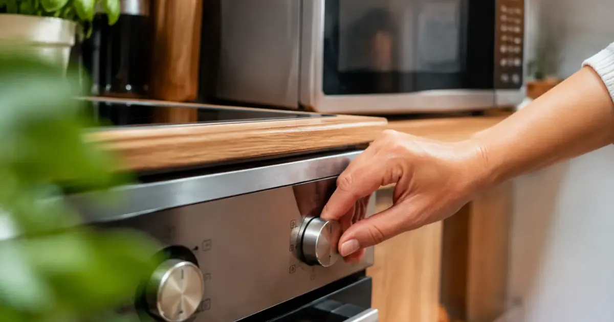 Main reglant le cadran dun four, micro ondes derriere