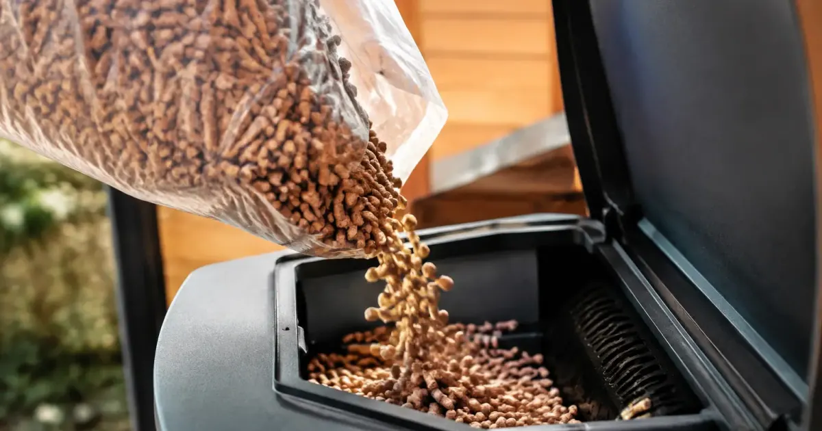 Mains gantees versant des granules dans un poele
