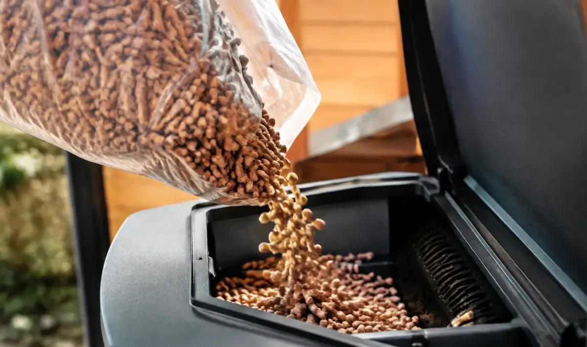 Mains gantees versant des granules dans un poele