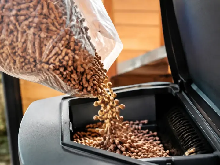 Mains gantees versant des granules dans un poele