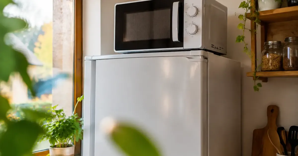 Micro-ondes pose sur le dessus du frigo blanc