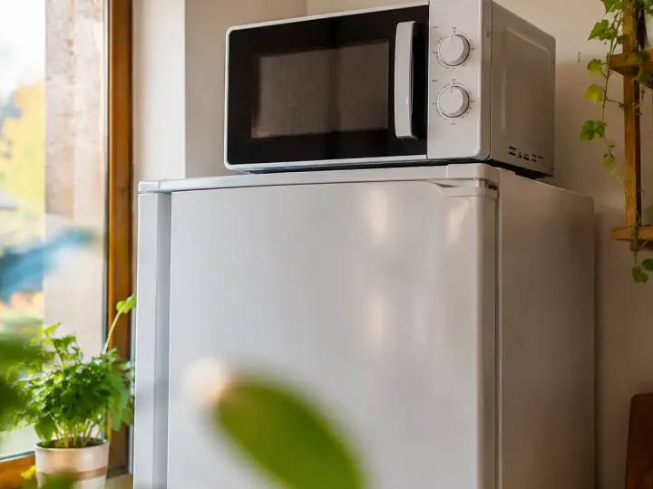Micro-ondes pose sur le dessus du frigo blanc