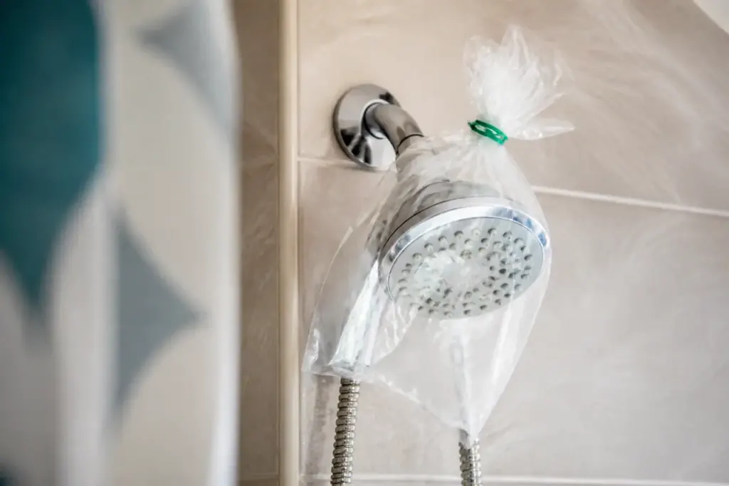 Pommeau de douche plonge dans sachet transparent avec elastique