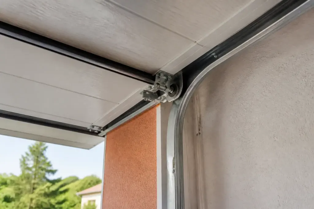 Porte de garage blanche ouverte, rail et galets visibles
