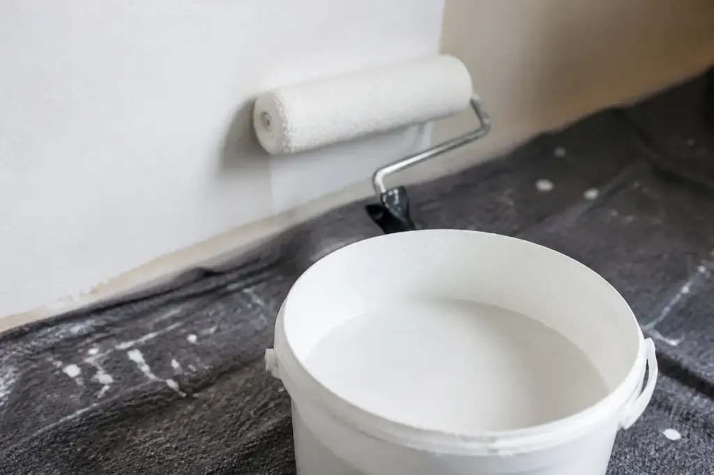 Pot de sous-couche blanche et rouleau sur mur