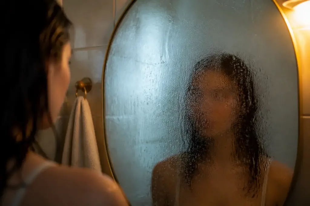 Salle de bain carrelée avec miroir couvert de gouttelettes