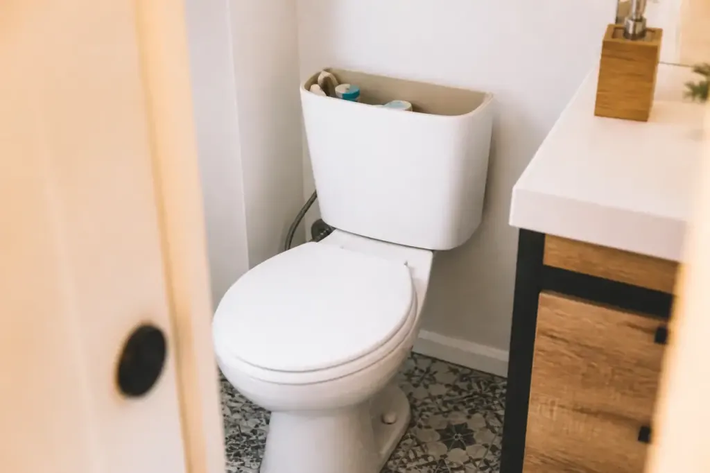 Toilettes blanches dans salle de bain avec reservoir ouvert
